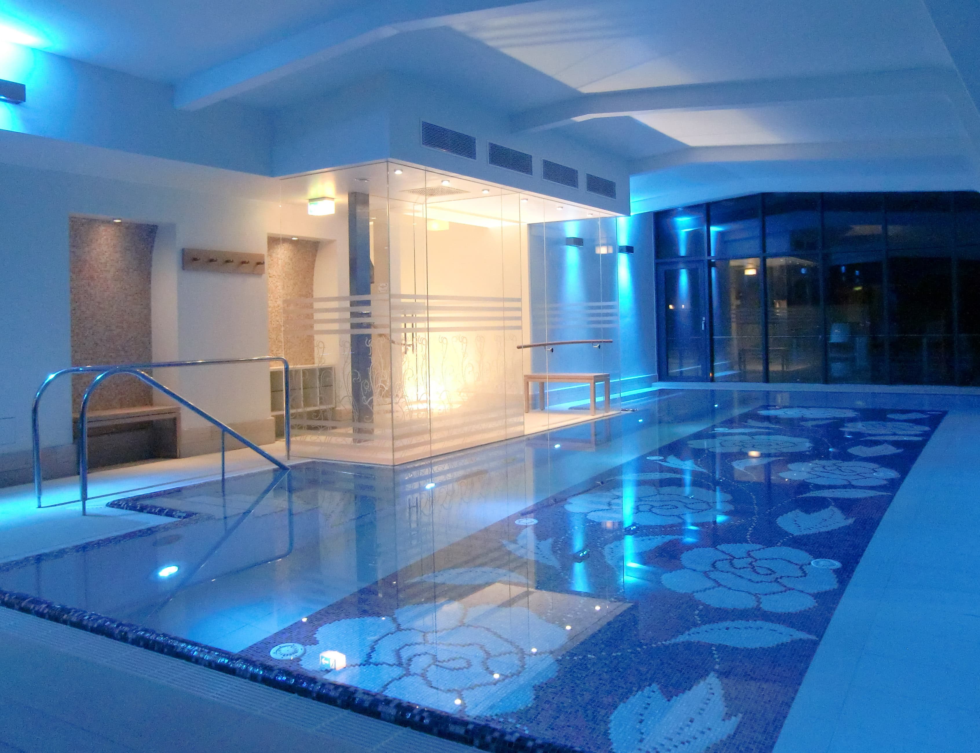 Hallenbad mit Mosaikbecken und Glaswand